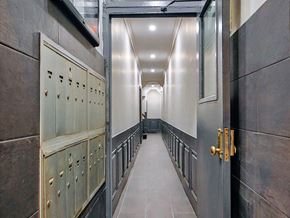 New York apartment for rent - a long hallway with rows of lockers and doors