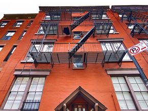 New York apartment for rent - a red brick apartment building with fire escapes