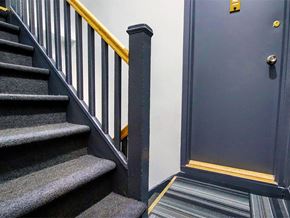 New York apartment for rent - a stairwell with a black door and stairs with a railing and