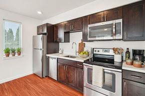 Seattle apartment for rent - A kitchen with dark wood cabinets and stainless steel appliances.