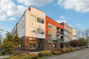 Seattle apartment for rent - A modern multi-story building with a mix of beige, brown, and grey panels.