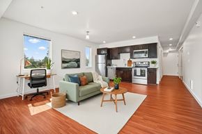 Seattle apartment for rent - A modern kitchen with a green couch and a wooden table.