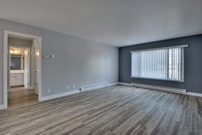 Redwood City apartment for rent - the living room of an empty apartment with wood flooring and a large window