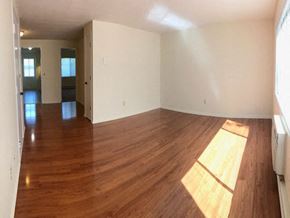 Branford apartment for rent - an empty living room with wooden floors and white walls
