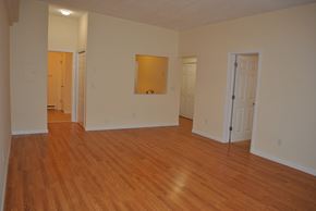 Guilford apartment for rent - an empty living room with wood flooring and white walls