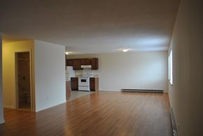 Guilford apartment for rent - an empty living room with wood floors and a kitchen