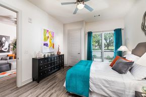 Dallas apartment for rent - Two Bedroom Apartments in Dallas, TX - Inwood Station Master Bedroom with Large Window, Wood-Style Flooring, and Ceiling Fan