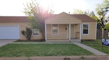 Abilene house for rent - a yellow house with a porch and a lawn
