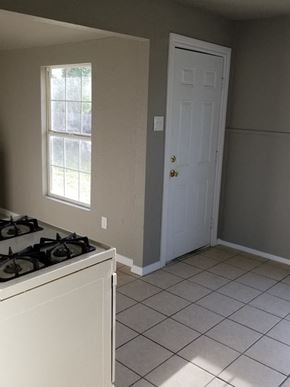 Abilene house for rent - an empty kitchen with a stove and a white door