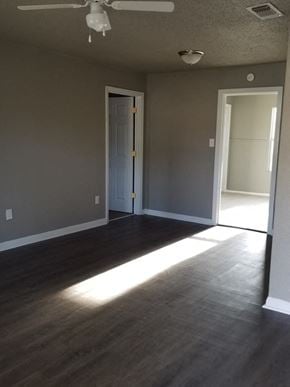 Abilene house for rent - an empty living room with wooden floors and a white door