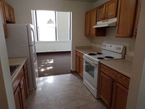 Rochester apartment for rent - an empty kitchen with white appliances and wooden cabinets
