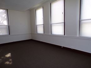 Rochester apartment for rent - an empty room with three windows and a carpet