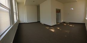 Rochester apartment for rent - an empty living room with a large window and a door
