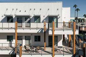 Mesa apartment for rent - a view of a white building with balconies and a deck with chairs