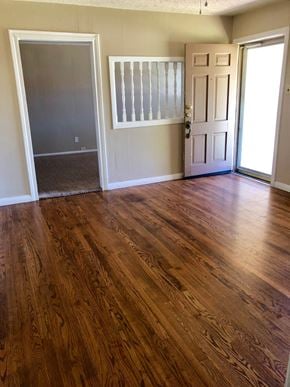 Abilene house for rent - A room with a wooden floor and a white door.