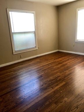 Abilene house for rent - A room with wooden floors and two windows.