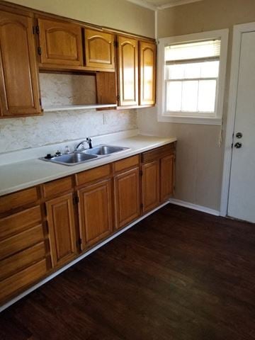 Abilene house for rent - A kitchen with wooden cabinets and a white sink.