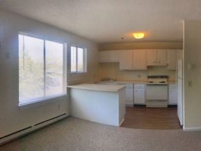 Guilford apartment for rent - an empty kitchen with white cabinets and a large window