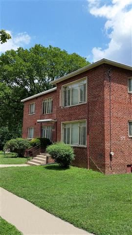 Washington apartment for rent - a red brick house with green grass and a sidewalk