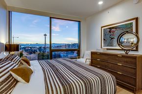 Seattle apartment for rent - a bedroom with a bed and a large window with a city view