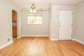 Denver apartment for rent - an empty living room with wood floors and a ceiling fan