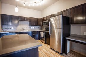 Sioux Falls apartment for rent - a kitchen with stainless steel appliances and dark wood cabinets