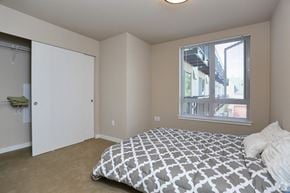 Seattle apartment for rent - a bedroom with a bed and a closet and a window