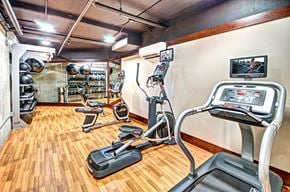 Seattle apartment for rent - a gym with various machines and weights on a wooden floor