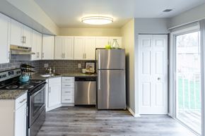 Owings Mills townhouse for rent - a kitchen with white cabinets and stainless steel appliances