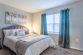 Owings Mills townhouse for rent - a bedroom with a bed and blue curtains