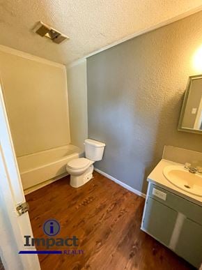 Abilene house for rent - A bathroom with a toilet, sink, and mirror.