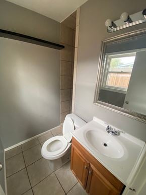 Abilene house for rent - a bathroom with a toilet and a sink and a mirror