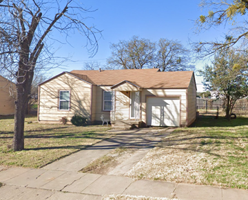 Abilene house for rent - a small tan house with a driveway and a tree