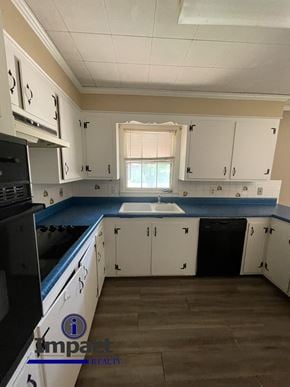 Abilene house for rent - A kitchen with white cabinets and a black stove top oven.