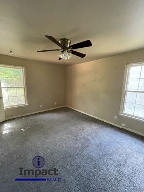 Abilene house for rent - A room with a ceiling fan and two windows.