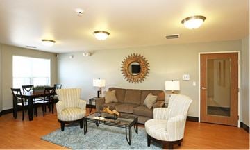 Cedar Rapids apartment for rent - a living room with a couch and chairs and a table
