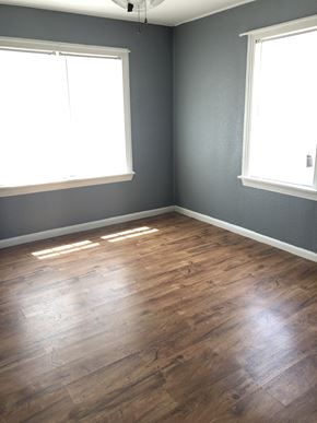 Abilene house for rent - an empty room with wood floors and two windows
