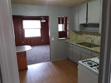 Abilene house for rent - an empty kitchen and living room with wood floors