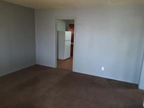 Abilene house for rent - an empty living room with a refrigerator in it