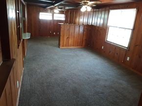 Abilene house for rent - an empty room with a carpeted floor and wooden walls
