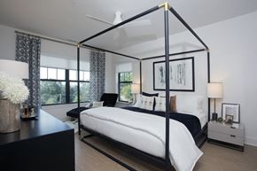 Peekskill apartment for rent - a bedroom with a large white bed and a black canopy bed