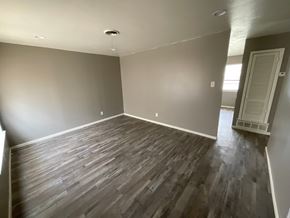 Abilene house for rent - A room with wooden flooring and a door on the right side.