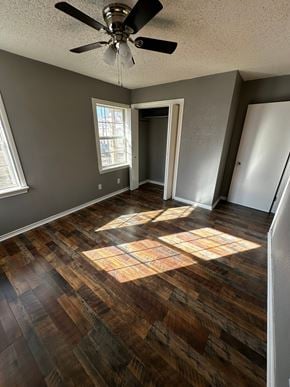 Abilene house for rent - an empty living room with wooden floors and a ceiling fan