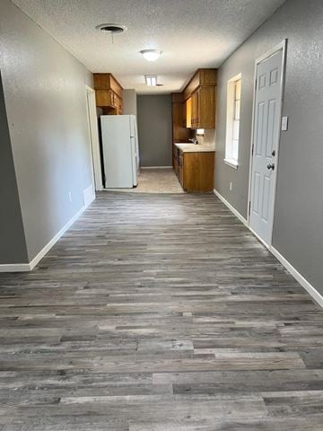 Abilene apartment for rent - a hallway with a kitchen and a white refrigerator