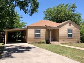 Abilene house for rent - a brown house with a driveway and a garage