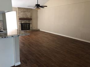 Abilene house for rent - an empty living room with wood flooring and a fireplace