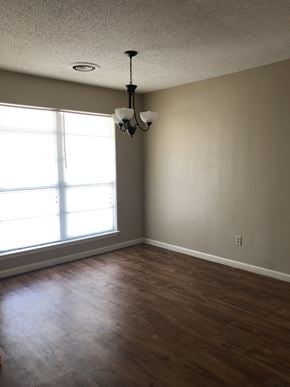 Abilene house for rent - an empty living room with wood floors and a large window