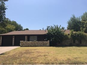 Abilene house for rent - a house with a brick wall in front of a grass field