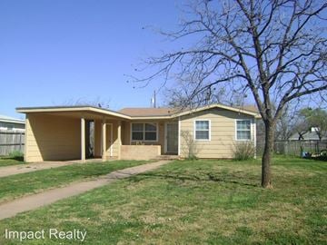Abilene house for rent - a yellow house with a tree in front of it