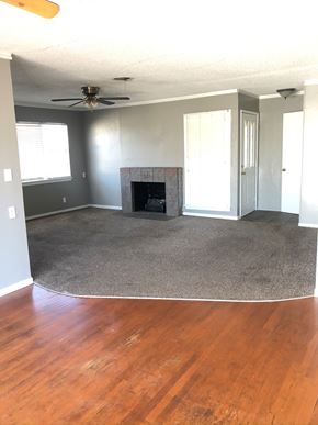 Abilene house for rent - an empty living room with a rug and a fireplace